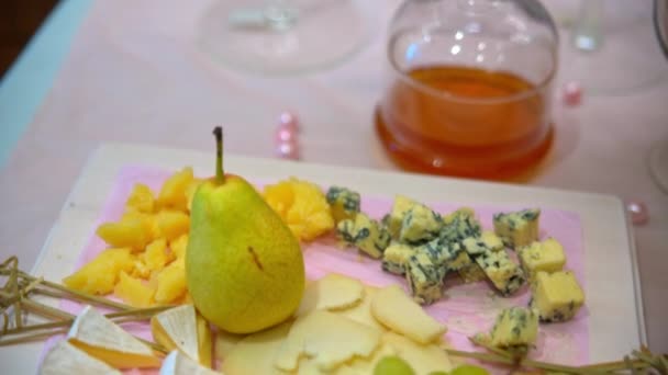 Шведский стол, сыр, виноград и груша лежат на поверхности — стоковое видео