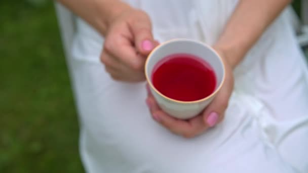Weiße Tasse Tee in den Händen der Mädchen — Stockvideo