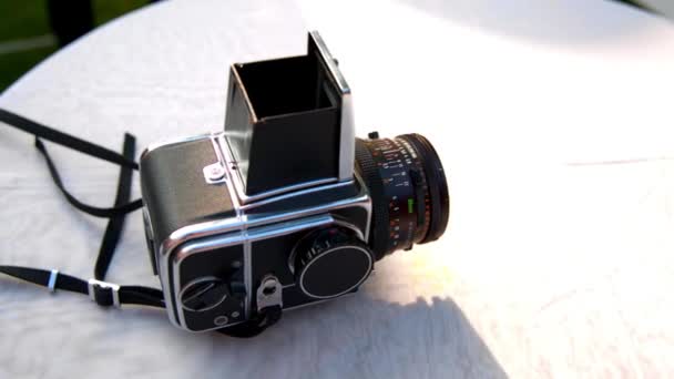 Hasselblad fotoğraf makinesi beyaz bir masanın üzerinde yatan — Stok video