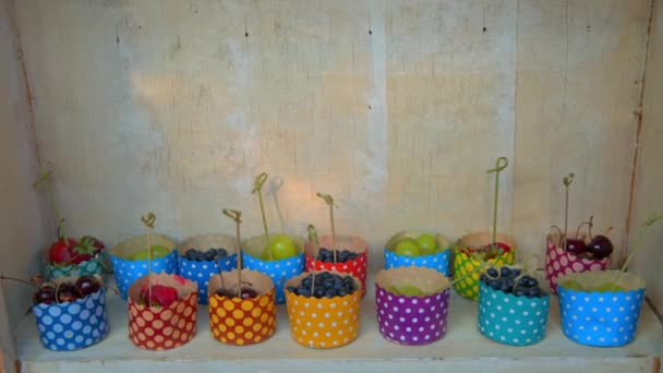 Ягоды в цветных чашках, виноград, клубника, вишня — стоковое видео