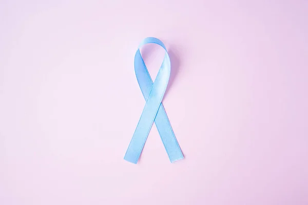 Prostate cancer awareness blue ribbon on pink background. — Stock Photo, Image