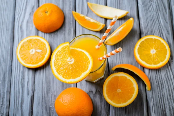 Composição com vidro de suco de laranja e frutas em um fundo de madeira. Foco seletivo, vista superior . — Fotografia de Stock