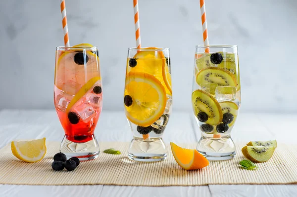 Variedad de limonada fría en un vaso con frutas y bayas — Foto de Stock