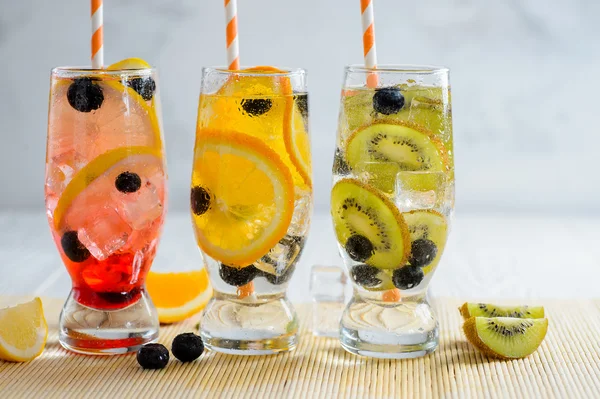 Різноманітність холодного лимонаду в склянці з фруктами та ягодами — стокове фото