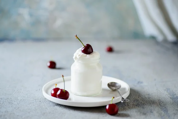 Cerejas vermelhas mergulhadas em chantilly ou iogurte — Fotografia de Stock