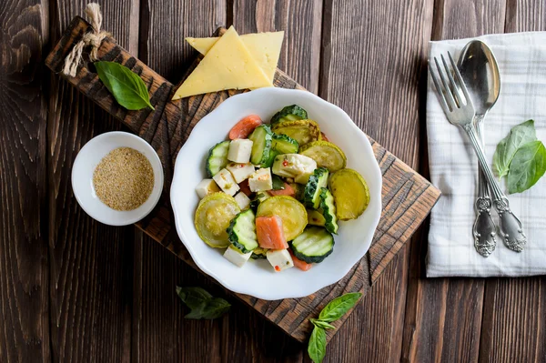 Plate with the fried vegetable marrows salmon salad on rustic table — Stock Photo, Image