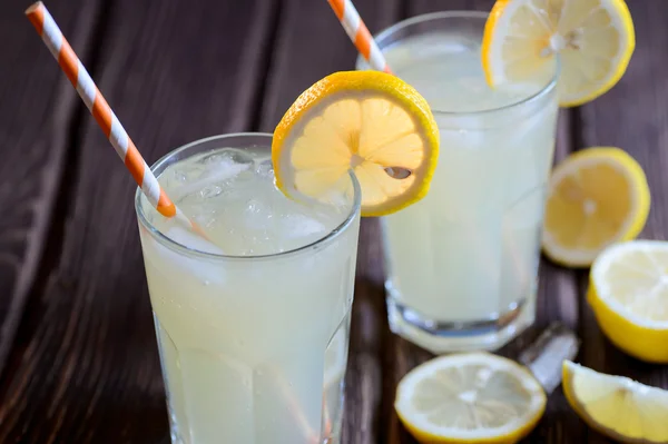 Eiskalte Zitruslimonade auf Holztisch vor natürlichem Hintergrund — Stockfoto