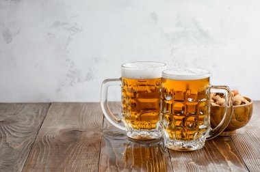 Ahşap bir masa üzerinde fıstık fındık ile iki Oktoberfest bira