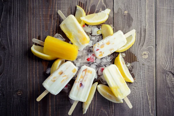 Refrescante picolé de frutas no fundo do gelo com pedaços de limão e maçã — Fotografia de Stock