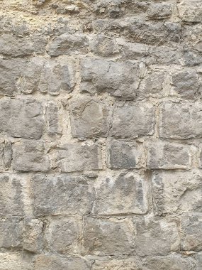 Büyük işlenmemiş bloklardan yapılmış eski bir taş duvarın dokusu. Doğal gri renk ve düz olmayan yüzey otantik bir tarihi görünüş yaratır. Mimari projeler için bir arkaplan veya doku olarak, tasarım