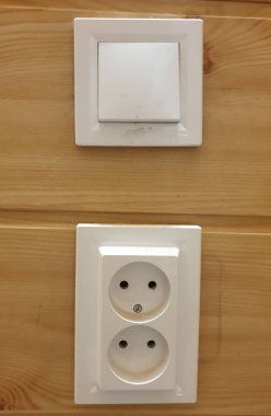 Elektrik düğmesi ve tahta bir duvara monte edilmiş iki elektrik prizi. Modern elektrik tesisatı ve doğal ahşap konfor, eko-stil ve minimalizm atmosferi yaratır. İçerisi için, elektrik.