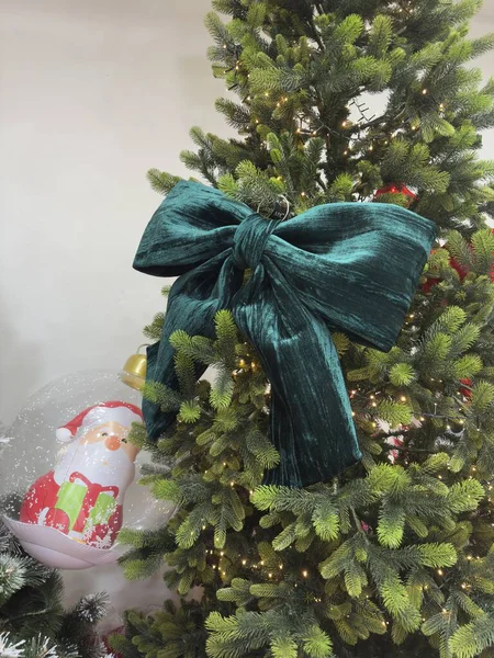 Lüks, büyük bir zümrüt kadife fiyonk bu güzel ışıklandırılmış yapay Noel ağacına zengin, şenlikli bir süs eşyası ekler..