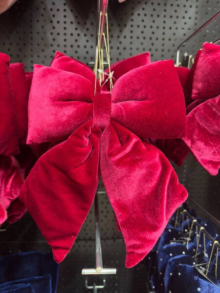 Роскошные красные бархатные луки волос отображаются на перфорированной черной стойке излучают праздничное очарование. Их плюшевая текстура и смелый цвет делают их идеальными для элегантного стиля или сезонных коллекций аксессуаров.