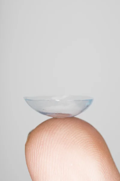 Contact lense on finger tip, macro from the side — Stock Photo, Image