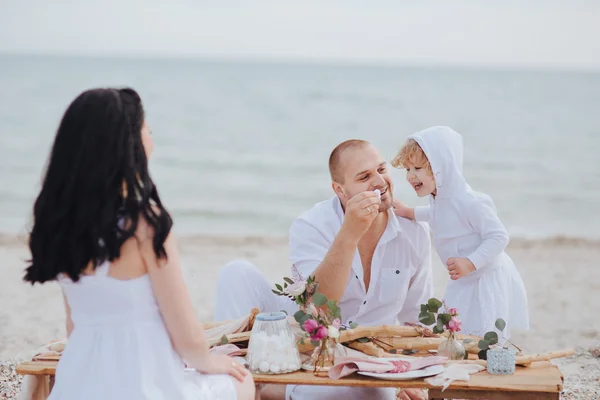 Familia sentada en una mesa cerca del mar —  Fotos de Stock