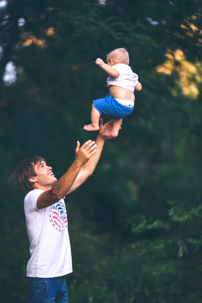 Pappa kastar upp en son uppåt — Stockfoto