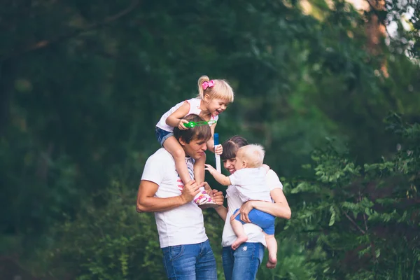 Junge Familie zu Fuß mit Kindern — Stockfoto