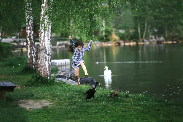 Kleines Mädchen springt auf eine Wiese — Stockfoto