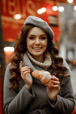 İkiz kardeşler bir restoranda ekmek ve kruvasanla kahve içiyorlar.