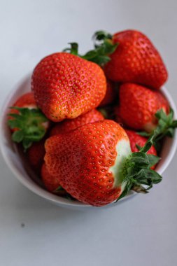 Beyaz arka planda bir kasede çilek