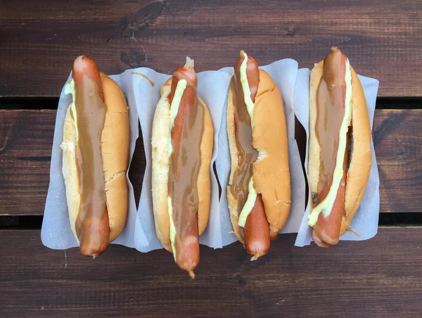 Hotdog, gestoomde worstjes geserveerd in een broodje met een keuze aan specerijen; ketchup, zoete mosterd, remouladesaus, krokant gebakken UI en rauwe ui. — Stockfoto