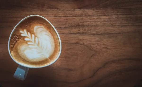 Latte art (bunga), Cangkir kopi di atas meja kayu — Stok Foto
