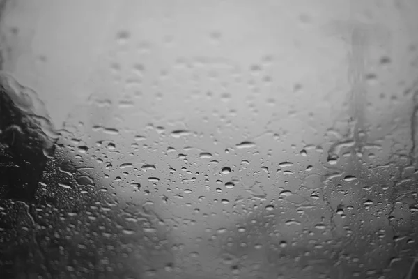 Picătură de ploaie pe un pahar cu accent pe un centru în stil de contrast scăzut — Fotografie, imagine de stoc