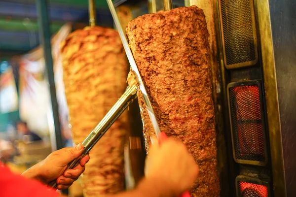 Chef's arm moving to cut a doner kebab meat — Stock Photo, Image