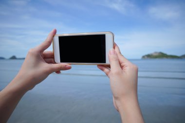 kadın kullanım akıllı telefon deniz fotoğrafını çekin, siyah monitör izole