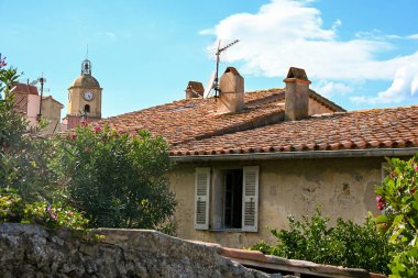 Saint-Tropez manzarası, pastel evlerini ve kilise kulesini gösteriyor.