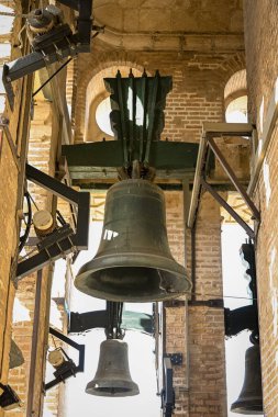 Sevilla 'daki Giralda Kulesi' nin içinde, tarihi, inancı ve Endülüs kültürünün ve geleneğinin yankılanan ruhunu simgeleyen güneş ışığıyla aydınlatılmış devasa bronz çanlar.