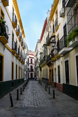Sevilla 'daki geleneksel Endülüs binasının güneşli köşesinde güney İspanya' nın mimari cazibesini yansıtan sarı çizgili beyaz duvarlar ve geometrik detaylar yer alıyor.