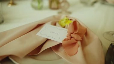 Pürüzsüz, yavaş çekim güzel dekore edilmiş uzun bir masa boyunca bir düğün resepsiyonu veya resmi bir ziyafet için hareket eder. Tabaklar, kristal bardaklar, pembe peçeteler ve...