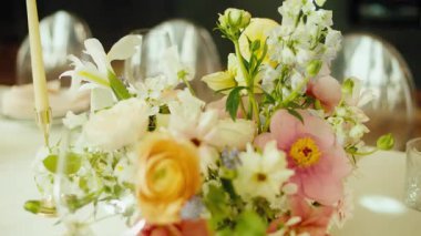 Pürüzsüz, yavaş çekim güzel dekore edilmiş uzun bir masa boyunca bir düğün resepsiyonu veya resmi bir ziyafet için hareket eder. Tabaklar, kristal bardaklar, pembe peçeteler ve...