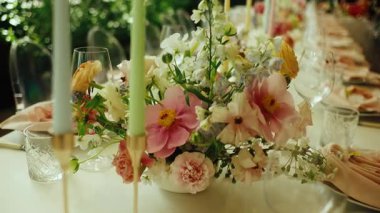 Pürüzsüz, yavaş çekim güzel dekore edilmiş uzun bir masa boyunca bir düğün resepsiyonu veya resmi bir ziyafet için hareket eder. Tabaklar, kristal bardaklar, pembe peçeteler ve...