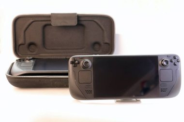 Portatif oyun konsolu açık bir kutunun önünde ikinci bir cihazla birlikte taşınabilir oyun konsolu. Görsel mobil oyun, cihaz koruması ve modern dijital yaşam tarzı kavramı.