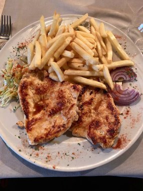 Kızarmış tavuk filetosu, patates kızartması, lahana salatası ve soğan.