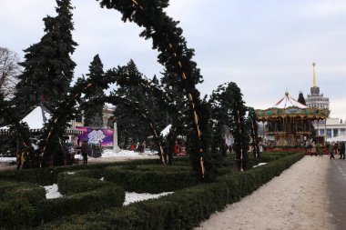 Atlıkarınca, kemer, kar ve açık alanda insanlar olan bir kış festivali.