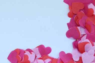 Açık arkaplanda dağınık kırmızı, pembe ve mor kağıt kalpler Sevgililer Günü için romantik bir tasarım..