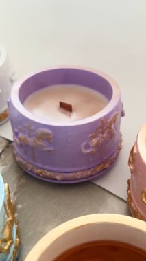 Süslü seramik mum tutacaklarında el yapımı soya mumları ahşap filizler ve altın aksanlı, lüks iç dekorları olan.