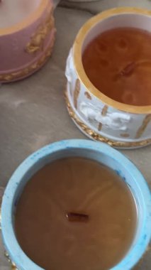 Enfes mum tutacaklarında altın parıltılı el yapımı soya mumları, lüks dekoratif ve refah kavramları için balmumu sertleştirme sürecinin yakın çekimi.