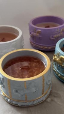 Enfes mum tutacaklarında altın parıltılı el yapımı soya mumları, lüks dekoratif ve refah kavramları için balmumu sertleştirme sürecinin yakın çekimi.