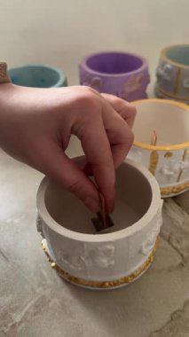 Mumlar için süslü bir alçı kalıbının içine yerleştirilen ahşap fitilin yakın plan çekimi, el yapımı lüks dekoratif mumlar.