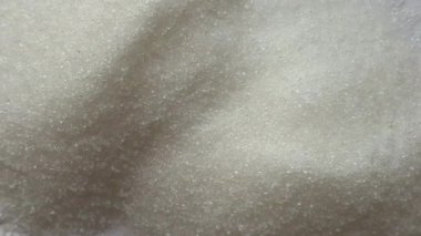 Dairesel hareket halindeki şeker kristallerinin genişletilmiş görüntüsü, aşçılık, sağlık ve yaratıcı tasarım projeleri için detaylı doku videosu