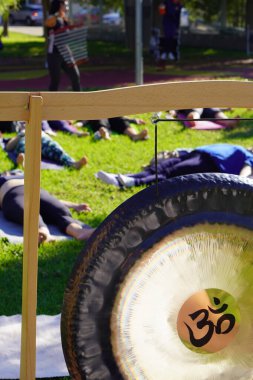 Alternatif tedavi Yoga seansı sırasında ön planda gong ve doğada ses banyosu.