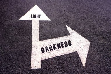Işık ve karanlık kavramları. Asfalta yazılmış kelimeler farklı yönleri gösteriyor..
