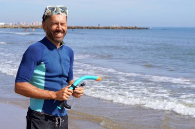 Akdeniz 'de tatil. Suya dalmadan önce orta yaşlı, mutlu bir adam. Dalgıç kıyafeti, gözlük ve şnorkel takıyor..