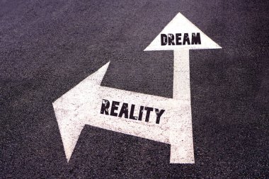 Rüya ve gerçeklik kavramları. Asfalta yazılmış kelimeler. Farklı yolları gösteren ok işaretleri