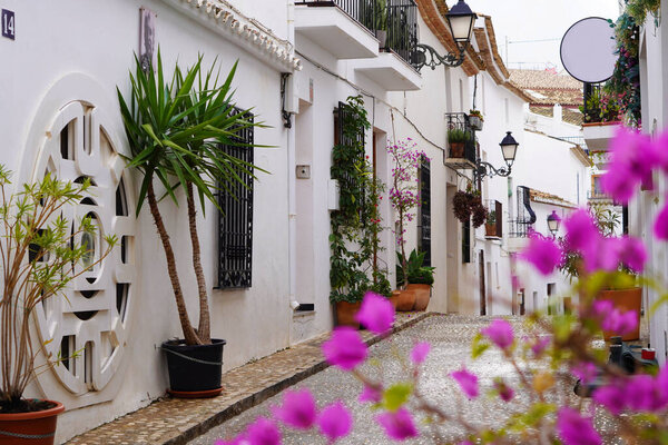 Spain Destinations and local heritage. Altea. Spain. Cobblestone street with white houses and colorful plants.