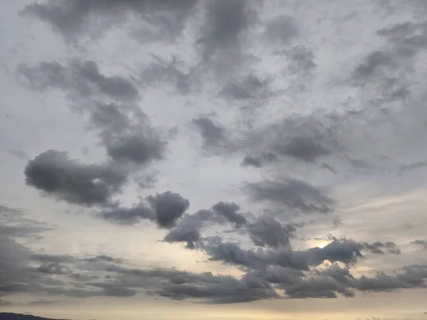 Güneş ufukta batarken bulutlar güzel gökyüzü boyunca uzanıyor. Bu manzara gerçekten büyüleyici, doğa fotoğrafçılığı için mükemmel bir zemin..